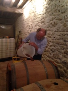 Hervé Jestin filling up barrels and informing the must